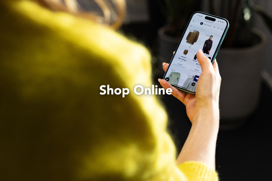 A phone in the hand, and Helsinki Outlet online shop on the screen