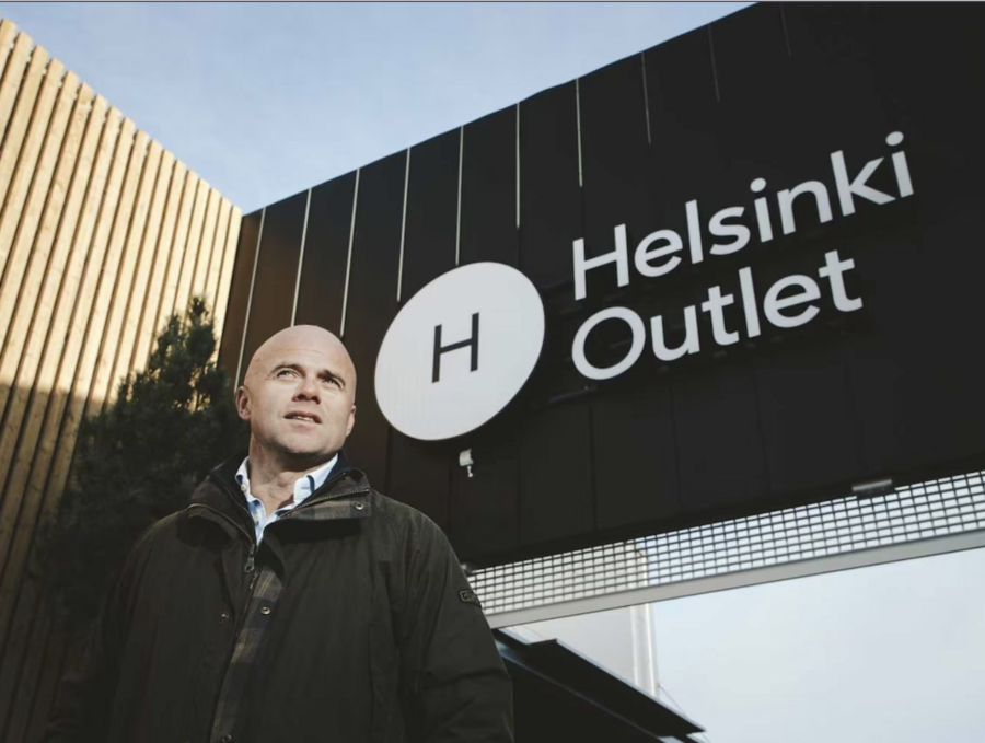Mies seisoo Helsinki Outletin sisäänpääsyn edessä.