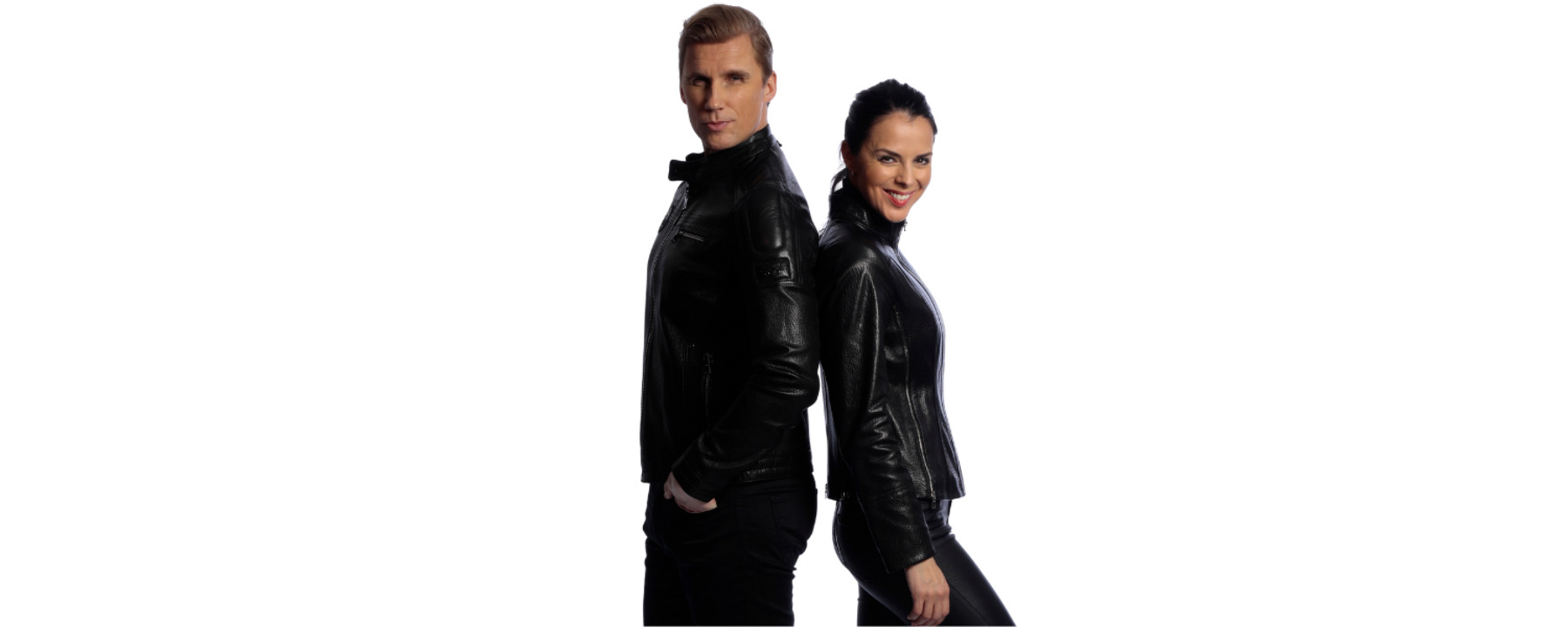 A man and a woman stand back to back wearing leather jackets