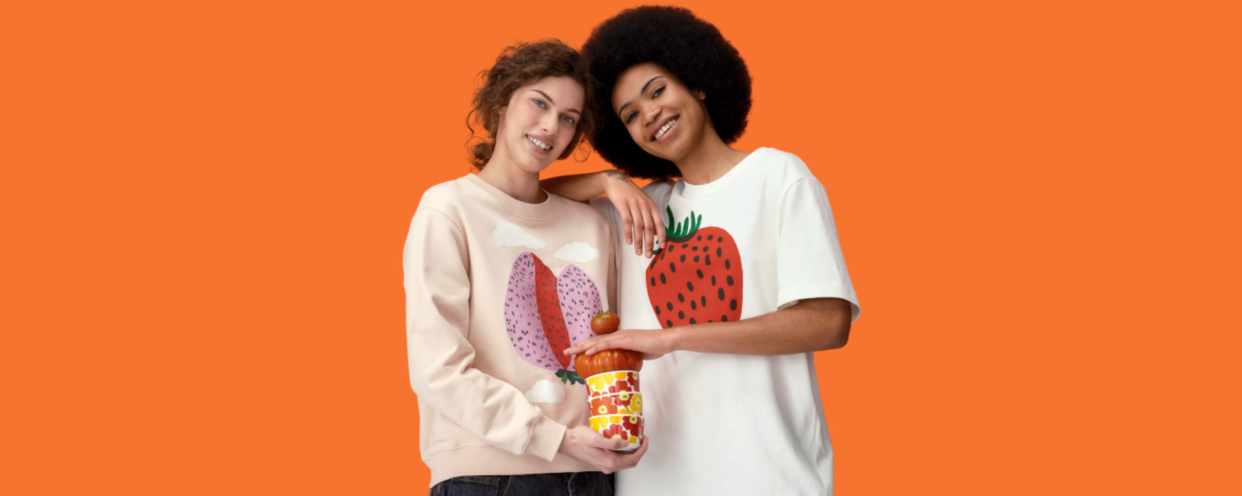Two women are holding Marimekko dishes together.