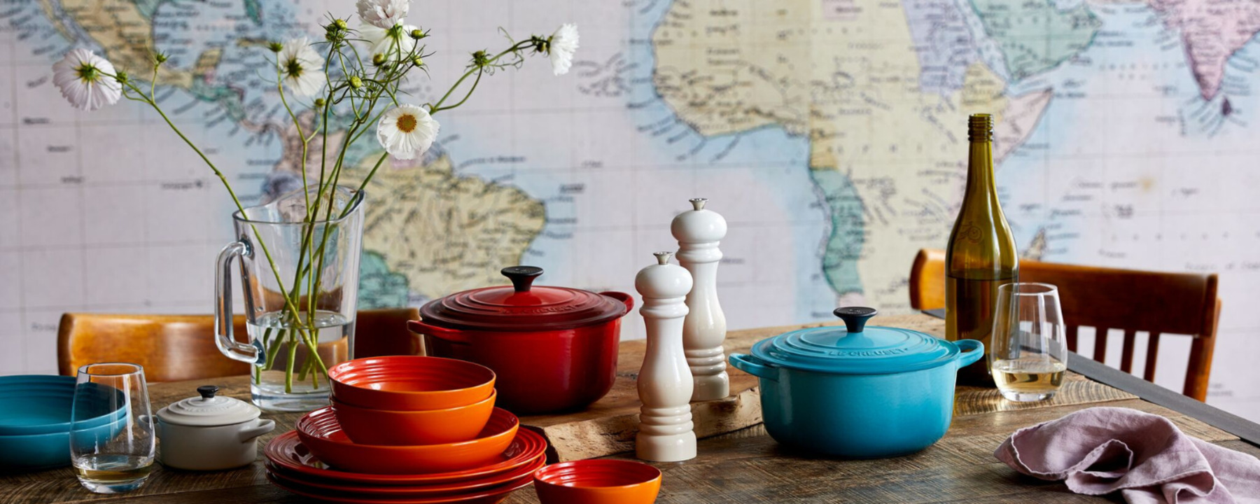 Colorful dishes and pots on the kitchen table with flowers