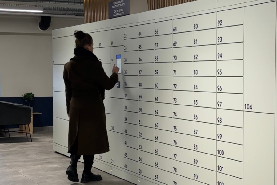 A woman is picking up her purchase from the Click & Collect locker