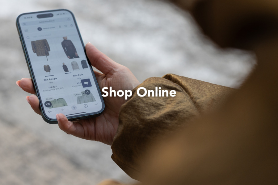 A phone in the hand, and Helsinki Outlet online shop on the screen