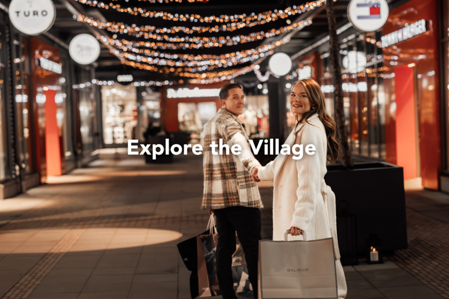 A couple shopping in the glow of Christmas lights — in the magical atmosphere of the outlet village