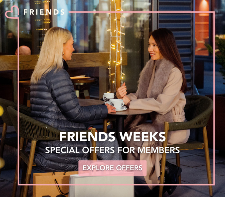Two women are having coffee on the terrace in the cold season.