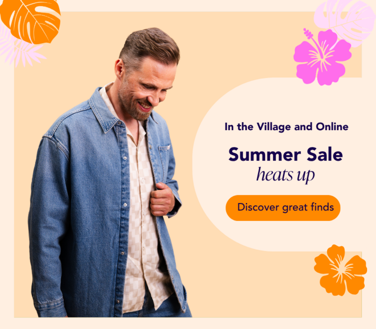 A man wearing a denim jacket on a light orange background with colorful carnival-themed decorations