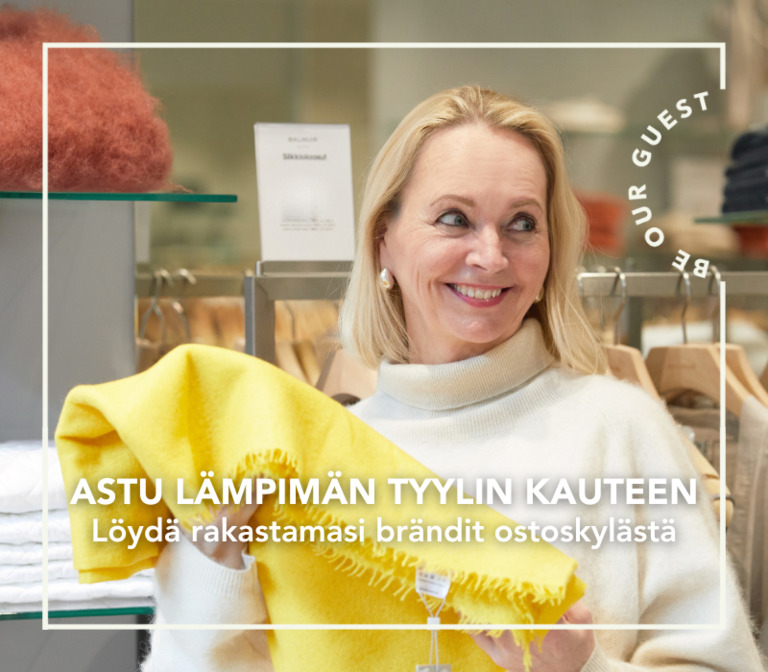 Nainen pitää käsissään kaunista keltaista huivia