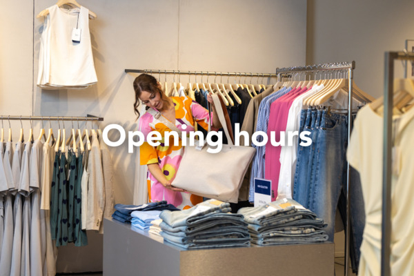 Interior of a clothing store showing racks and shelves of clothes. The image is labeled “Opening hours”.