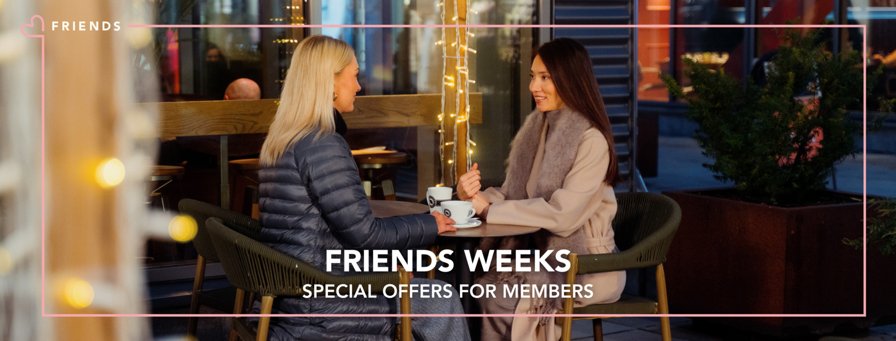 Two women are having coffee on the terrace in the cold season.