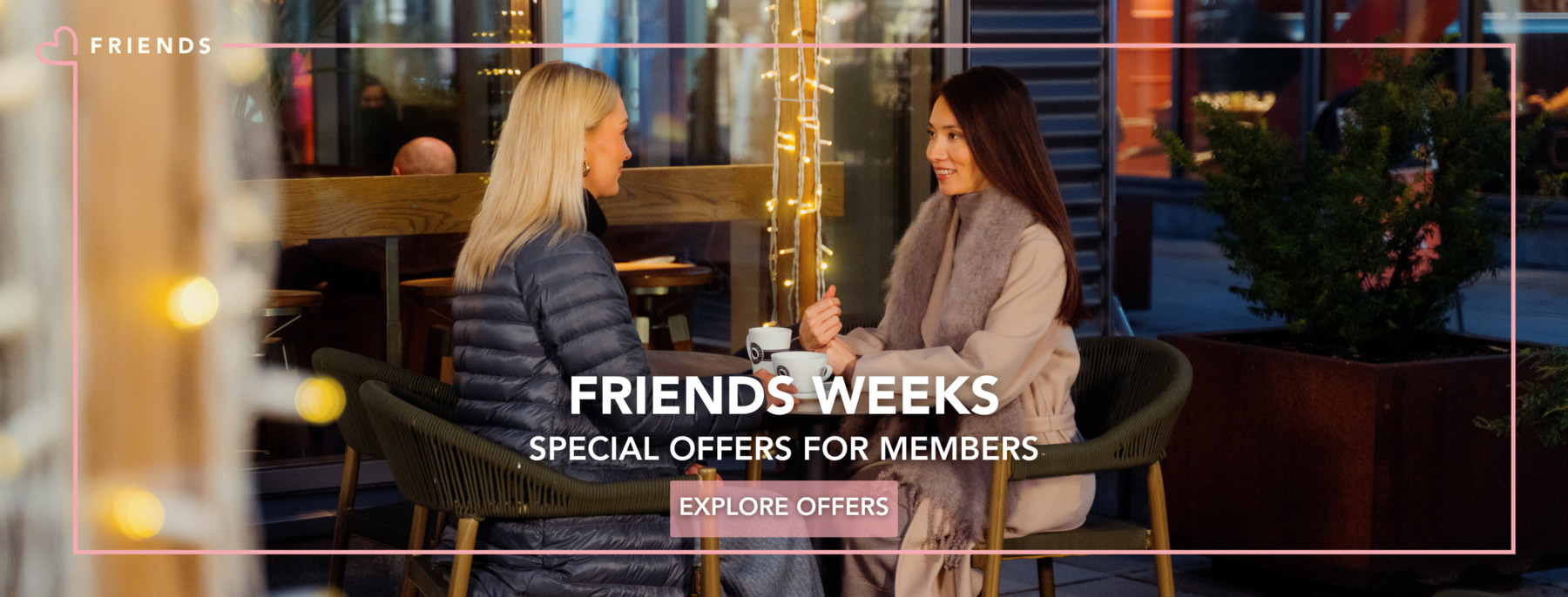 Two women are having coffee on the terrace in the cold season.