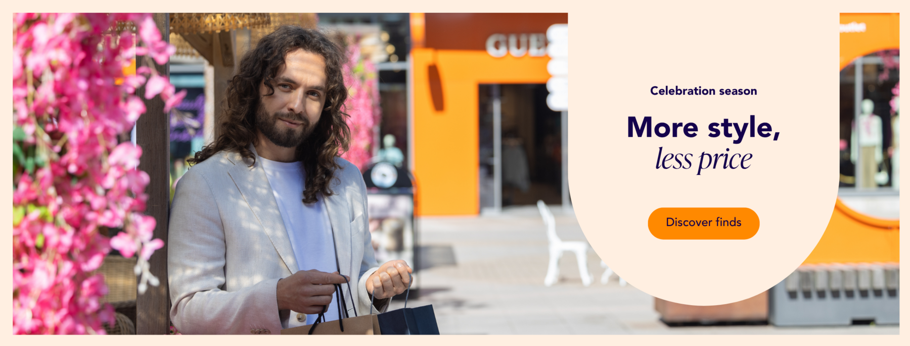 A man shopping at the summer-decorated Helsinki Outlet with bags in his hands.
