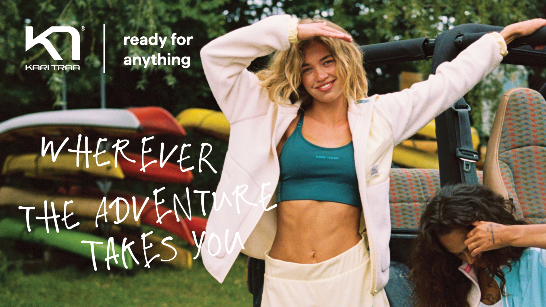 A woman smiling at the camera with surfboards in the background