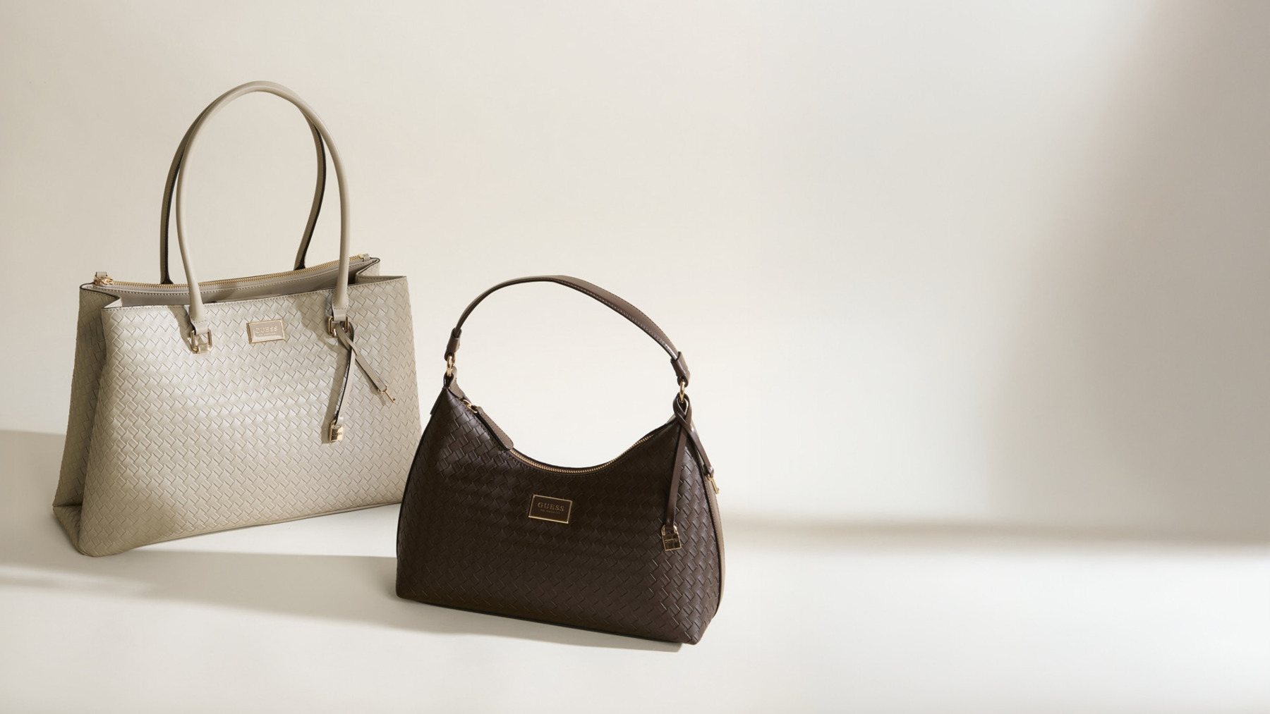 Two bags in brown neutral colours photographed in a studio