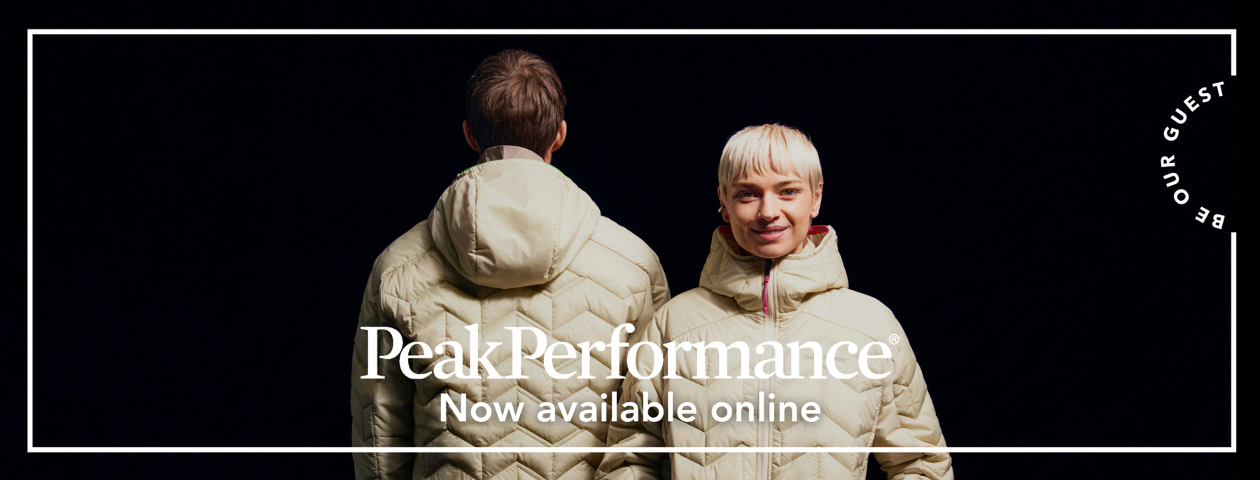 A man and a woman in ivory Peak Performance jackets on a black background