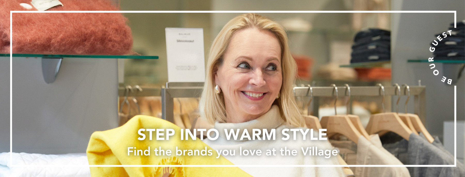 A woman is holding a beautiful yellow scarf in her hand