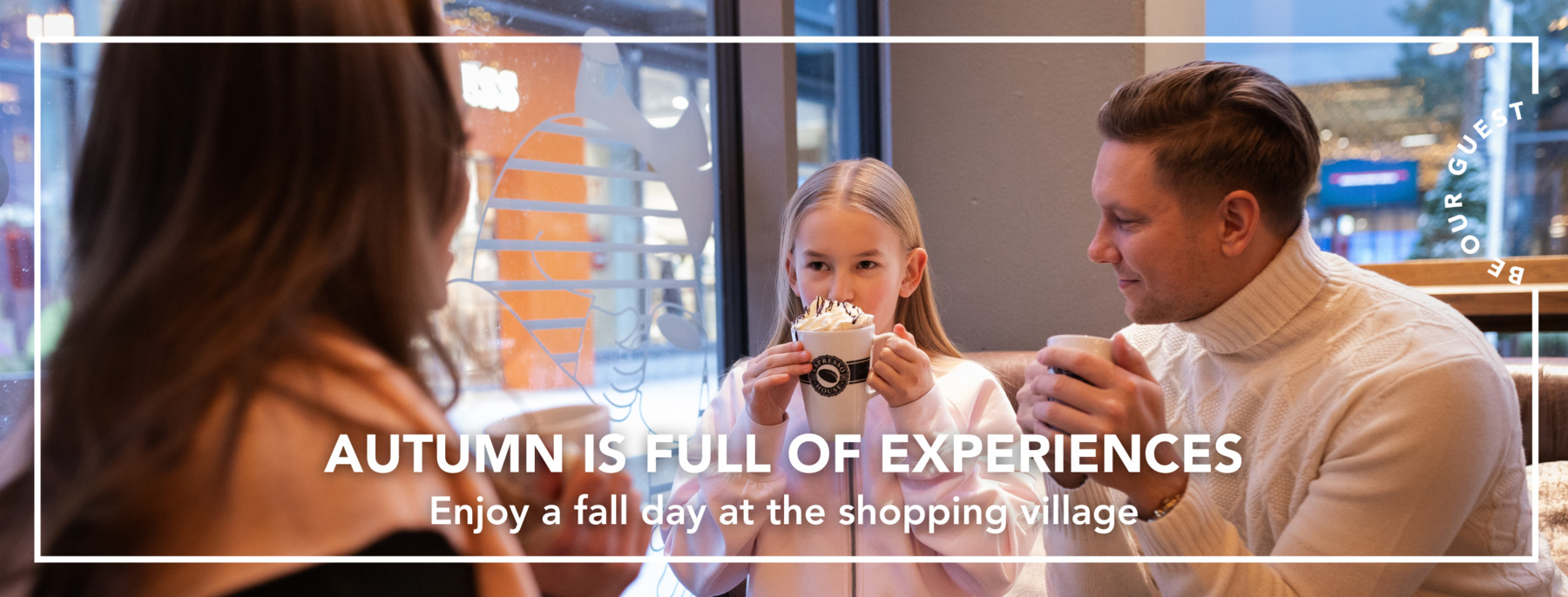 A family is having cups of hot drinks at Espresso House in the shopping village
