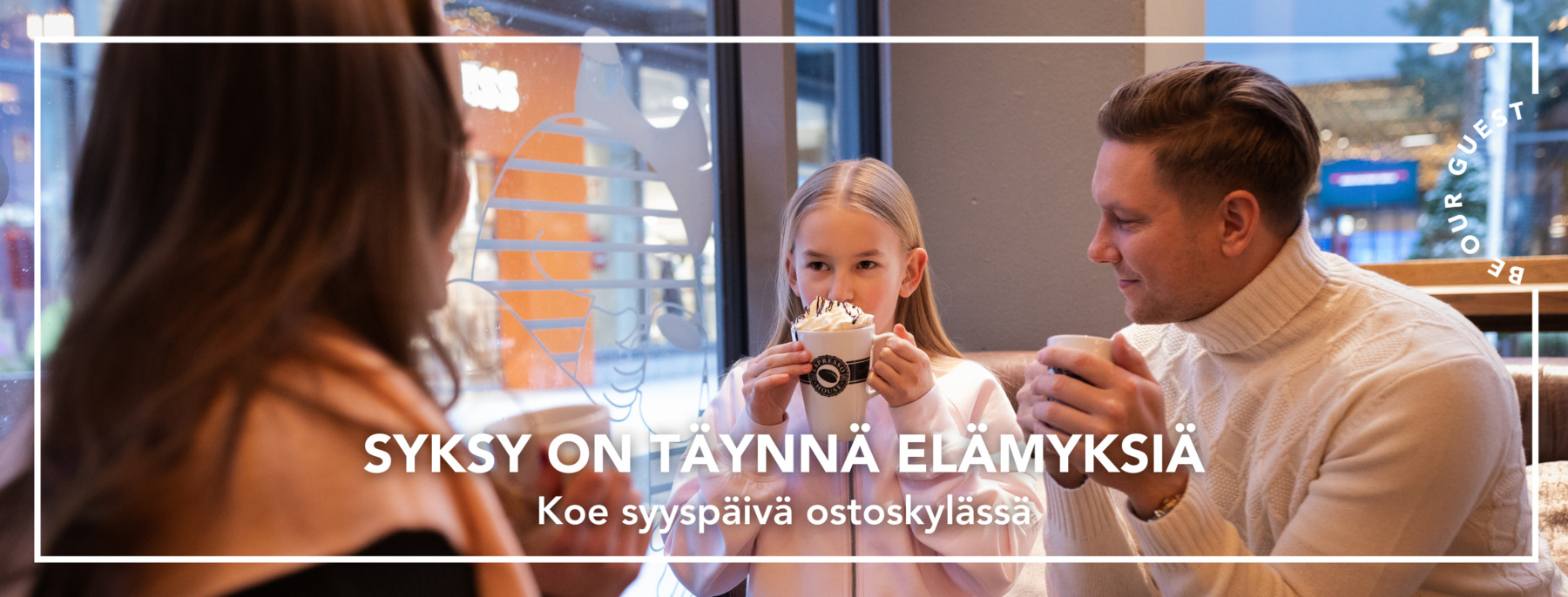 Perhe nauttii kuumia juomia Espresso Housessa ostoskylässä